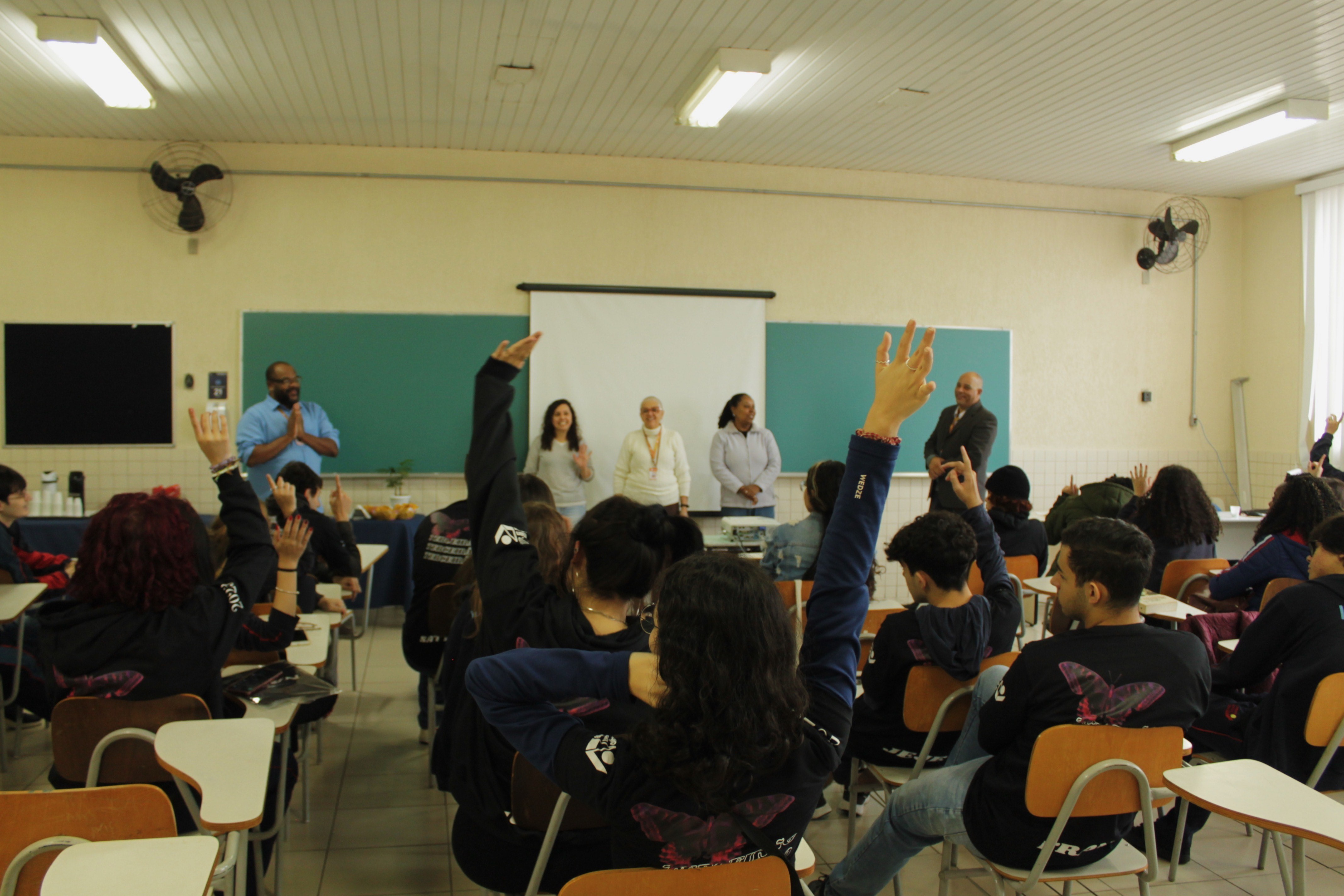 Alunos levantam a mão em palestra no Bibliomatinal.