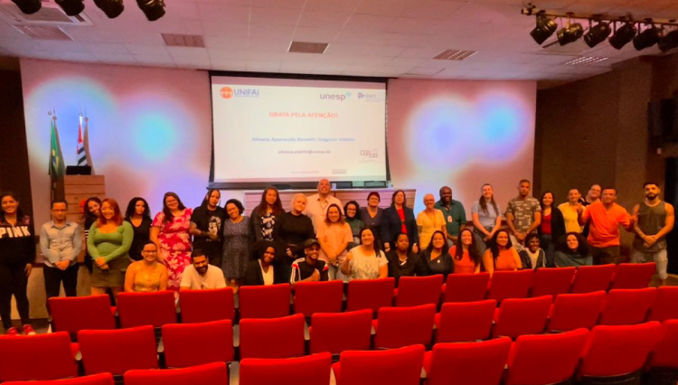 Alunos se posicionam embaixo do palco com a palestrante, no final da aula magna.