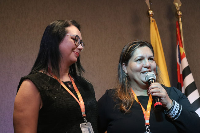 Lilian Gentil, bibliotecária da instituição, e Prof.ª Dr.ª Valéria Batista Edo, pró-reitora de Graduação, parabenizam os alunos ao final das apresentações.