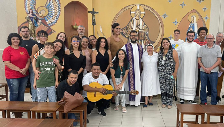 Participantes da missa, juntos, posam para foto ao final da celebração religiosa.