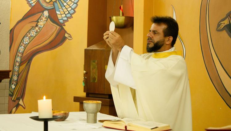 Padre Leomar mostra a óstia durante missa realizada na capela do UNIFAI.