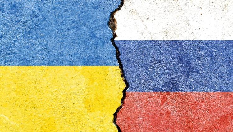 Bandeiras da Ucrânia e da Rússia pintadas em um muro rachado.