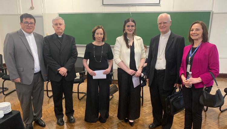 Seis pessoas posam para a foto. A segunda pessoa da direita para esquerda é o Dom Odilo Scherer ao lado da reitora do UNIFAI, professora Karen Ambra.