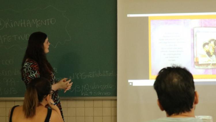 Reitor Profa. Karen Ambra, à lousa, capacitando, em sala de aula, os candidatos à vaga de padrinhos afetivos.