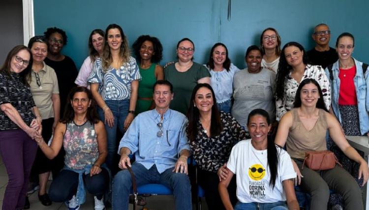 Alunos, voluntários e palestrantes posam para foto em sala de aula.